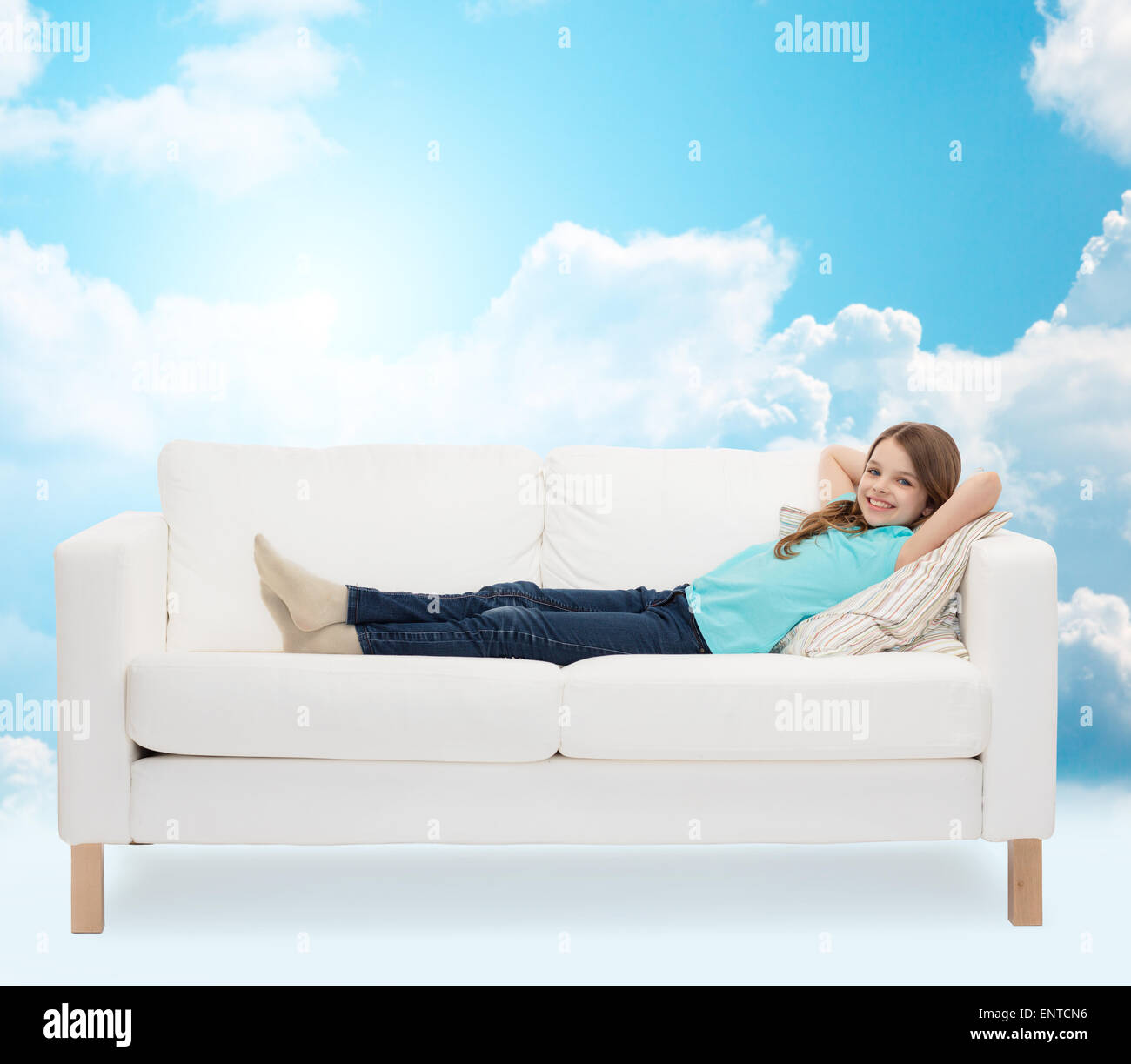 smiling little girl lying on sofa Stock Photo - Alamy