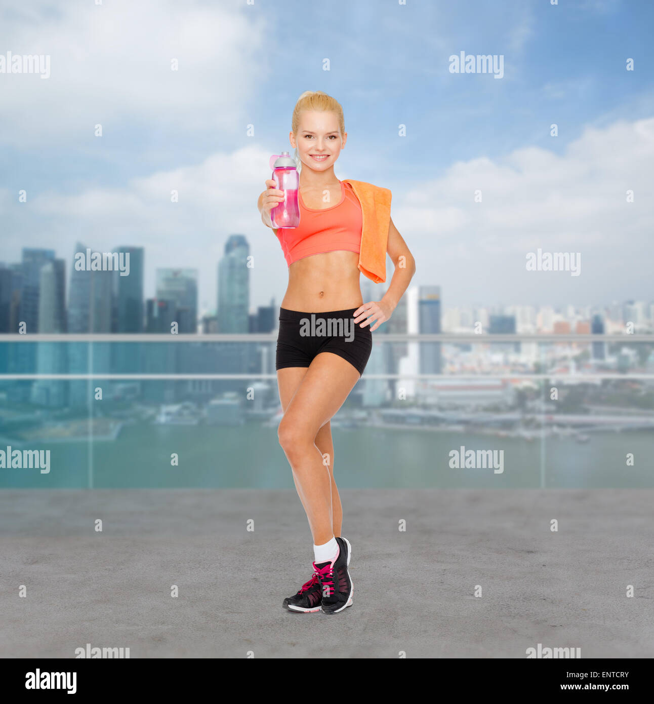 smiling sporty woman with water bottle and towel Stock Photo - Alamy