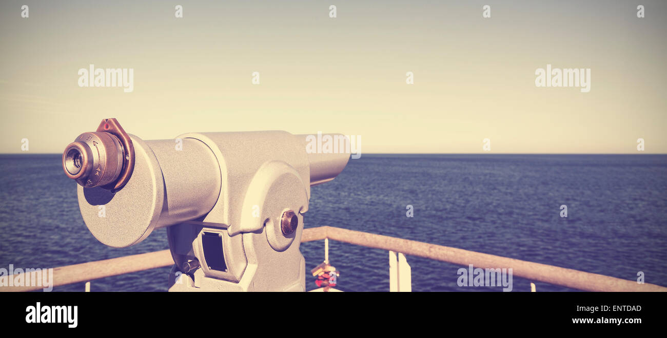 Retro vintage toned photo of a telescope on a pier pointed at horizon, future concept. Stock Photo