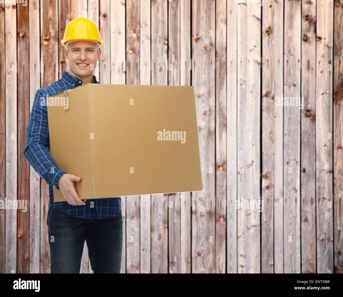 smiling male builder in helmet with cardboard box Stock Photo
