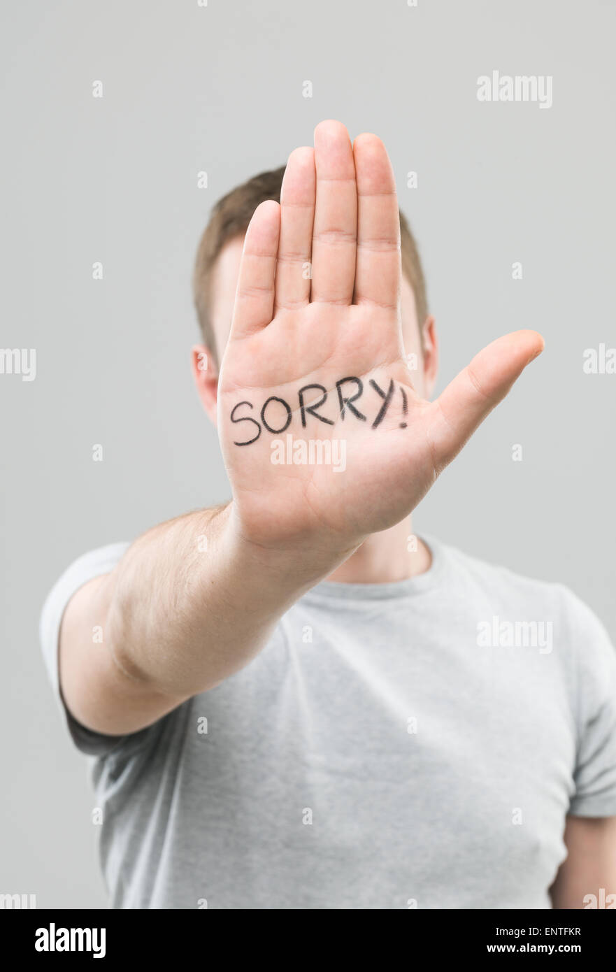 close-up of male hand with sorry message written on it Stock Photo