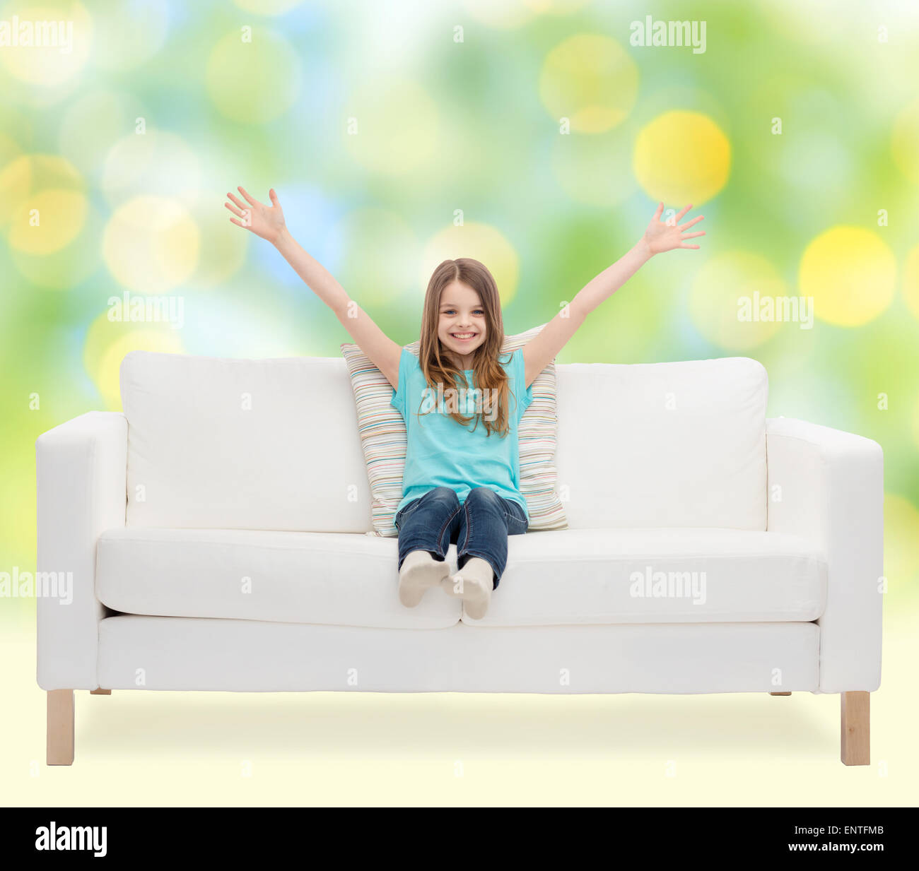 happy girl sitting on sofa with raised hands Stock Photo - Alamy