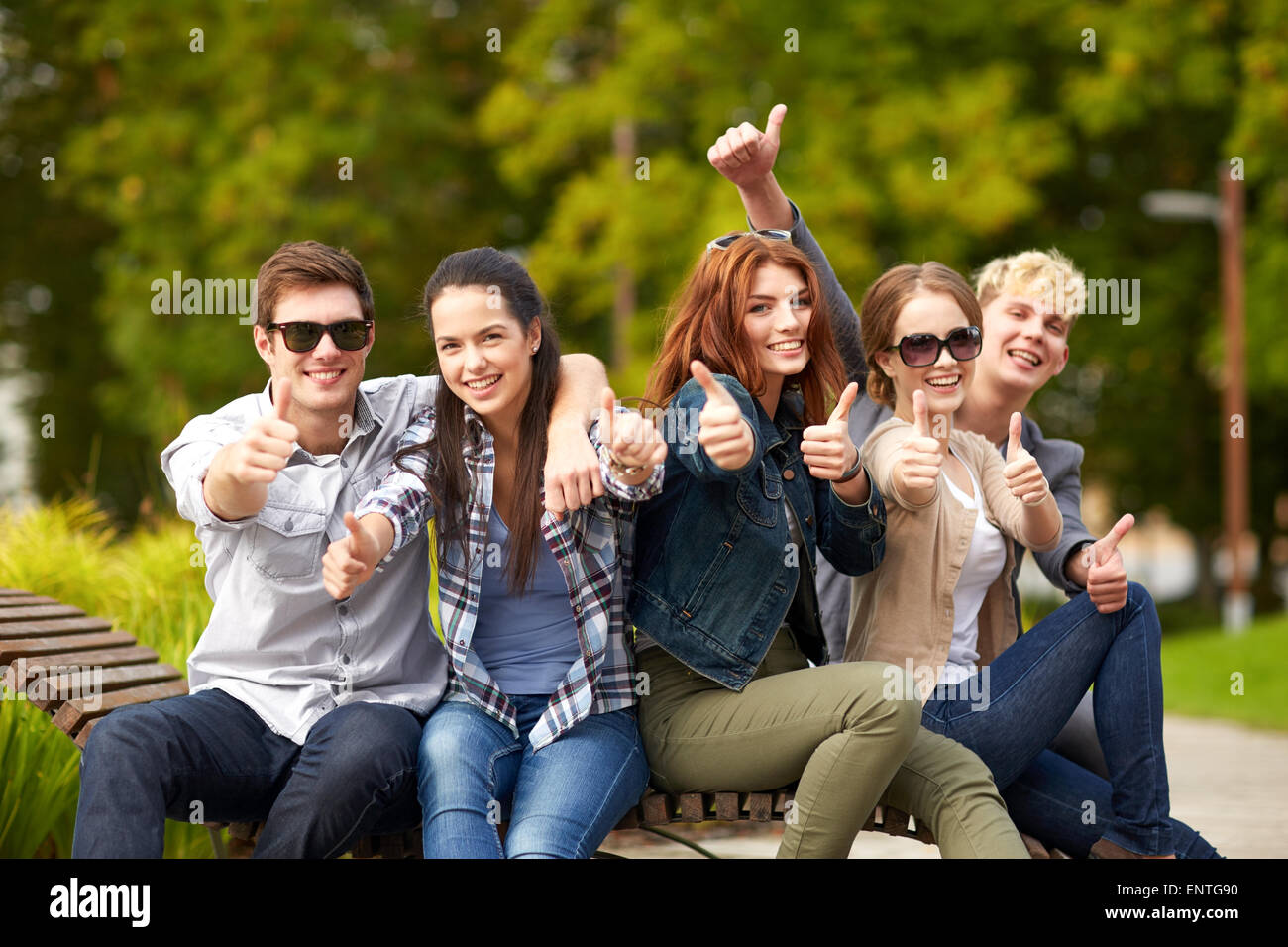 Студенты поднимают руки. Человек радостный. Счастливые студенты. Молодые люди. Довольный подросток.