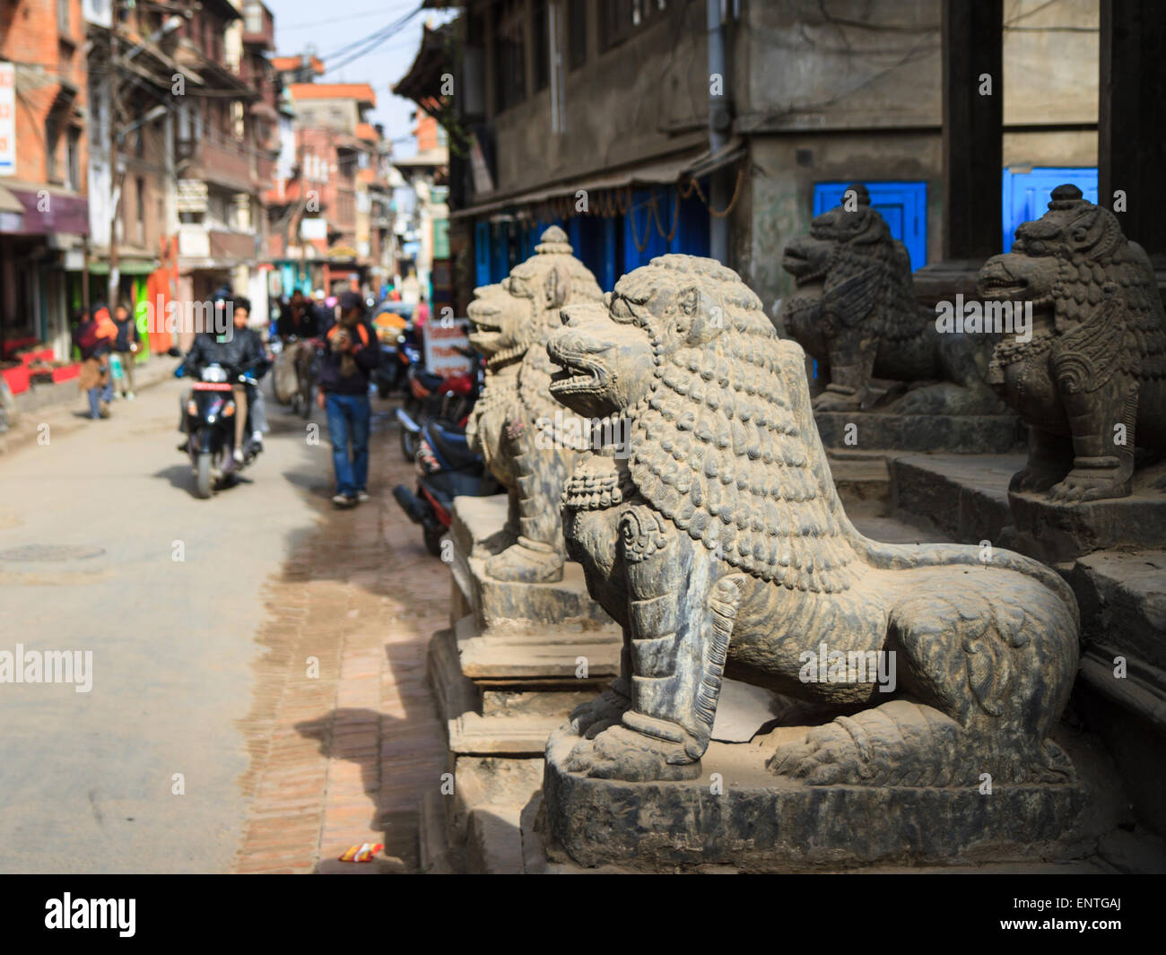 Lions at entrance to neighbourhood temple along typical street in historic Patan, Kathmandu, Nepal Stock Photo