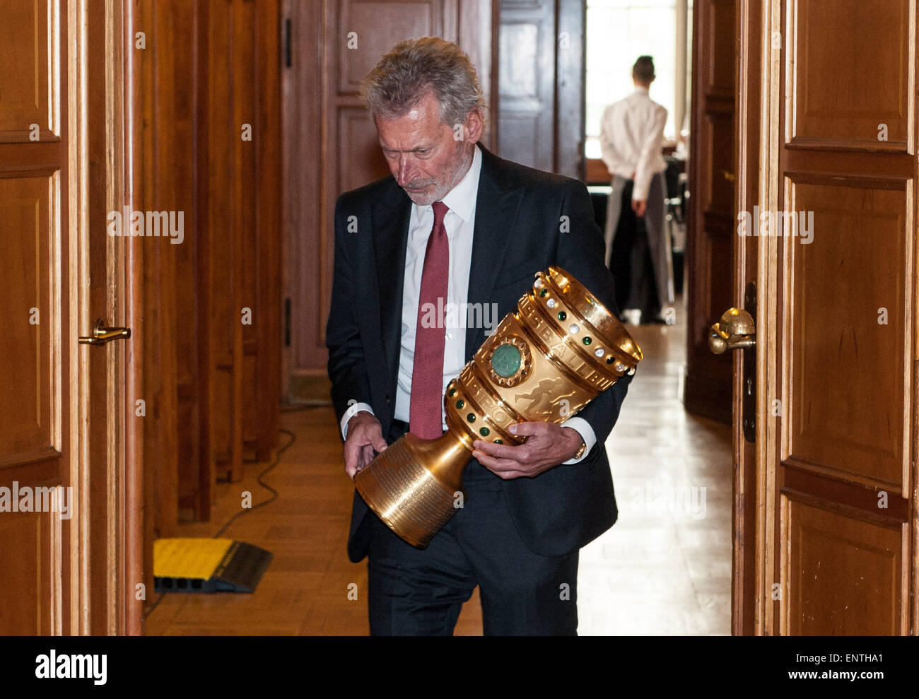 Berlin, Germany. 11th May, 2015. Former German soccer player Paul Breitner carries the DFB Cup to the Rotes Rathaus (Red City Hall) in Berlin, Germany, 11 May 2015. PHOTO: PAUL ZINKEN/dpa/Alamy Live News Stock Photo