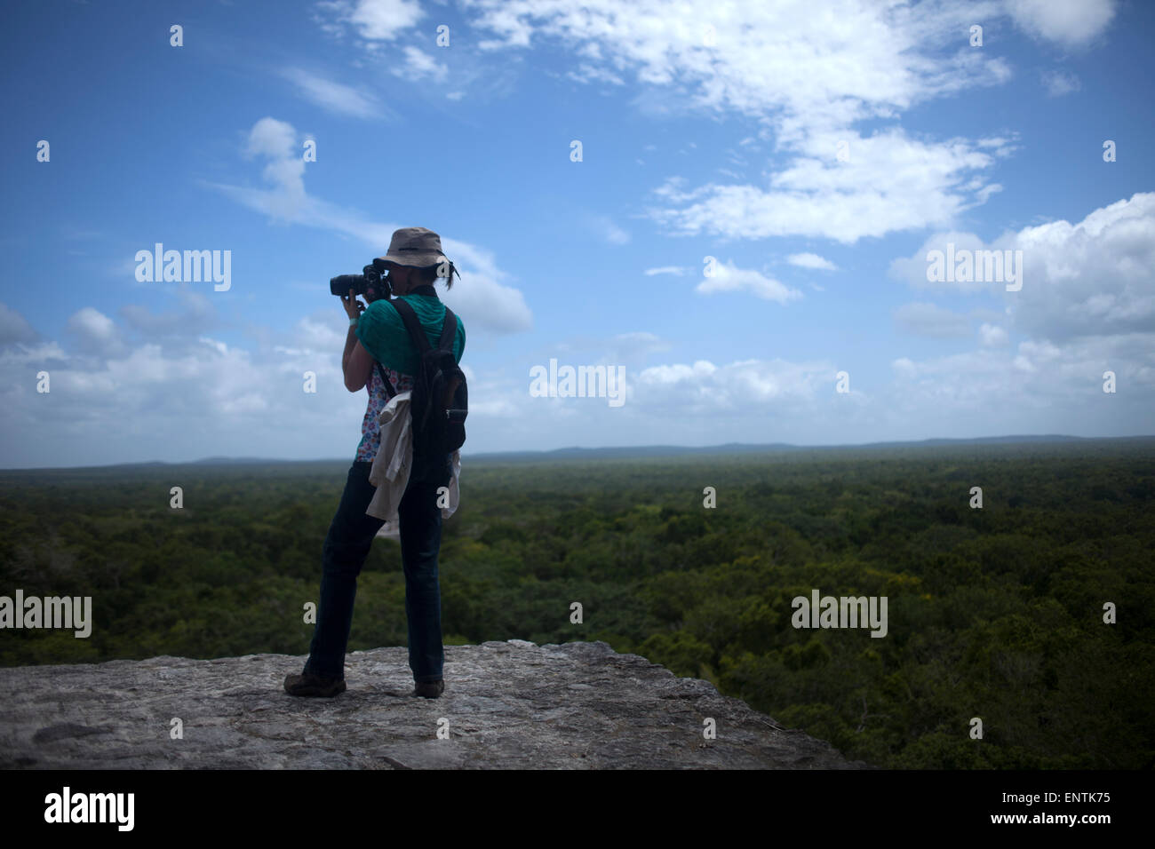 A photographer takes pictures of the jungle of top of a temple in the Mayan city of Calakmul, in Calakmul Biosphere Reserve, Campeche state, Yucatan Peninsula, Mexico Stock Photo