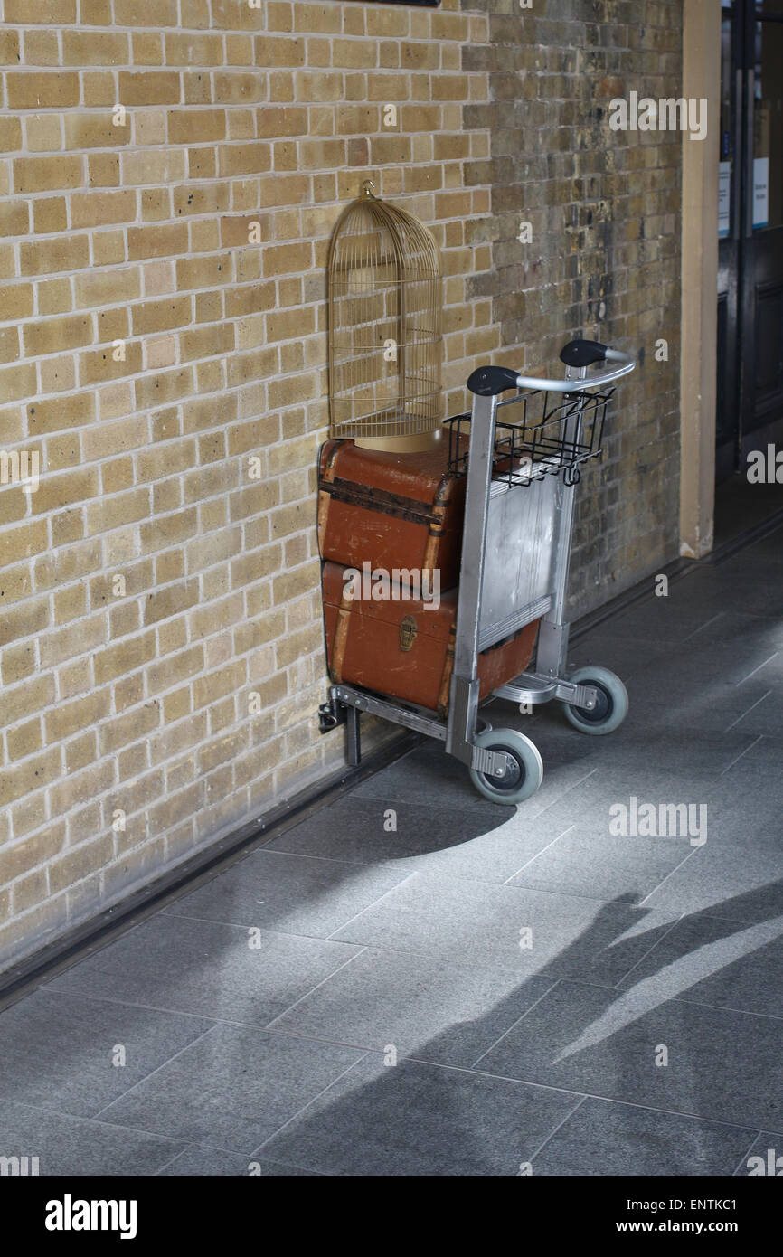 Luggage trolley disappearing through a wall hires stock photography