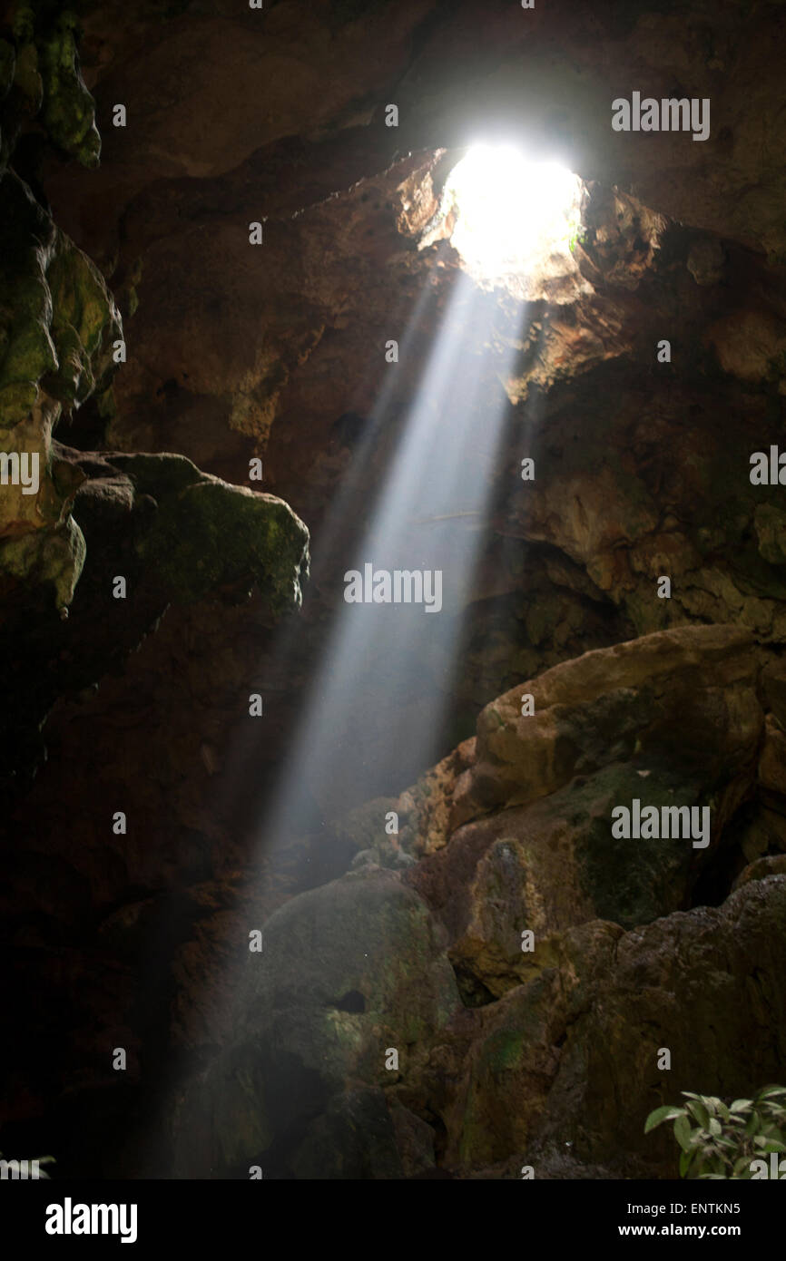A ray of sun light enters the Calcehtok Mayan caves near Oxkintok in Yucatan Peninsula, Mexico. These caves are where for the ancient Mayans an entrance to Xibalba, the underworld. Stock Photo