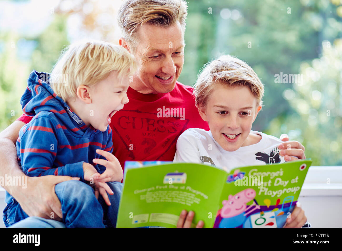 Father reading book to children Stock Photo