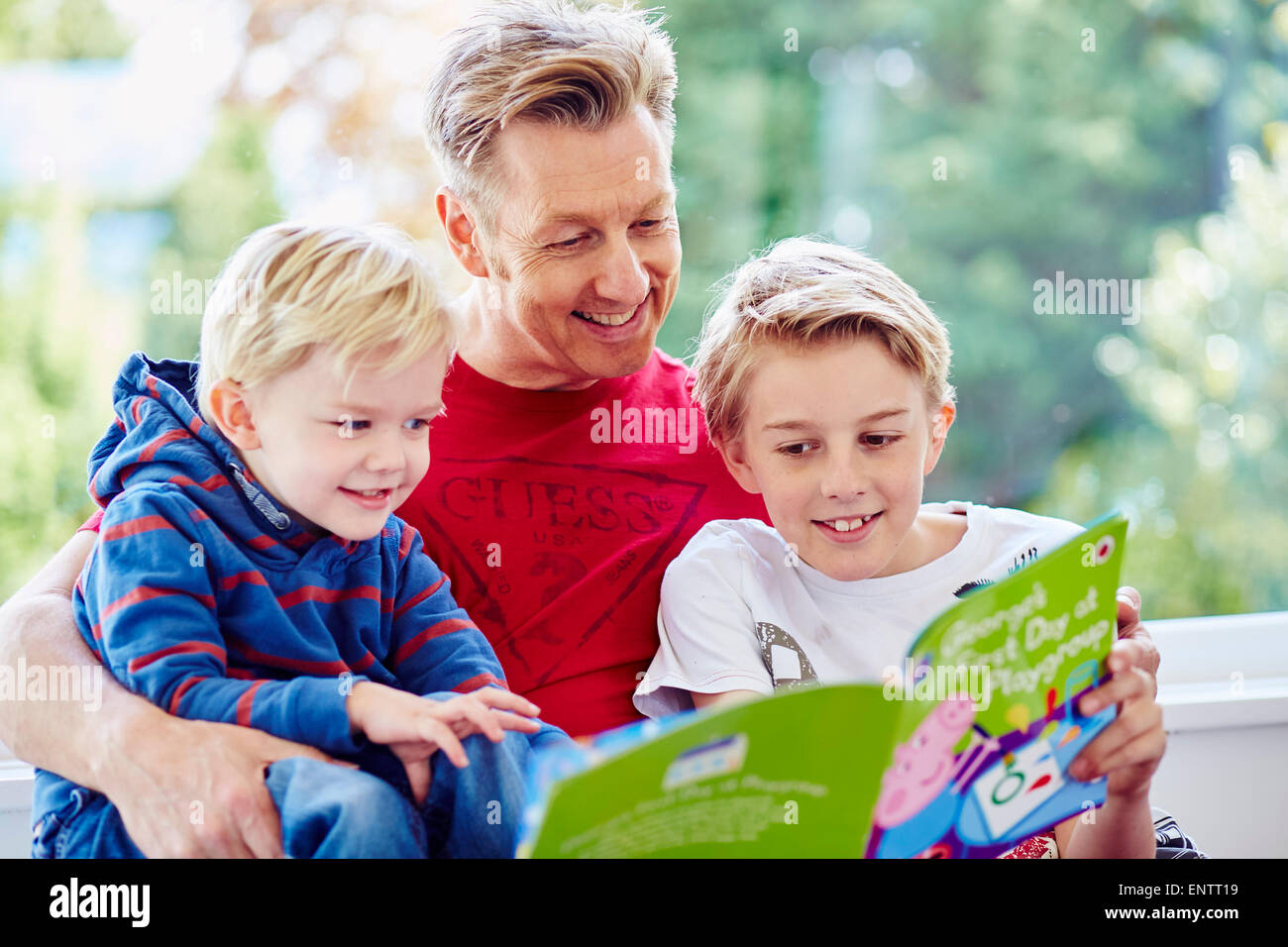 Father reading book to children Stock Photo