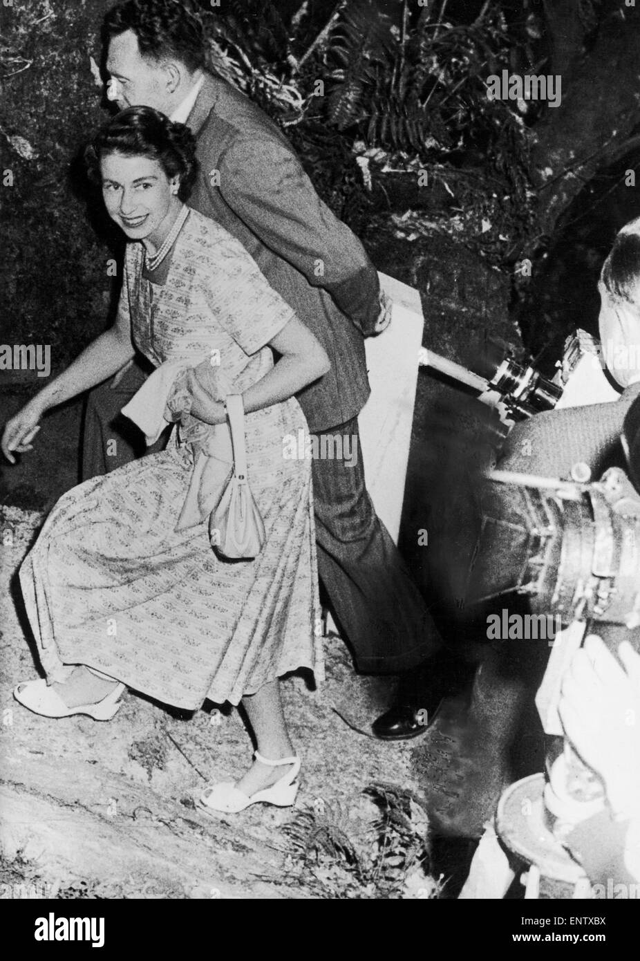The Queen climbing over rocks to see a cave in Waitomo, New Zealand. 11th Jan 1954 Stock Photo