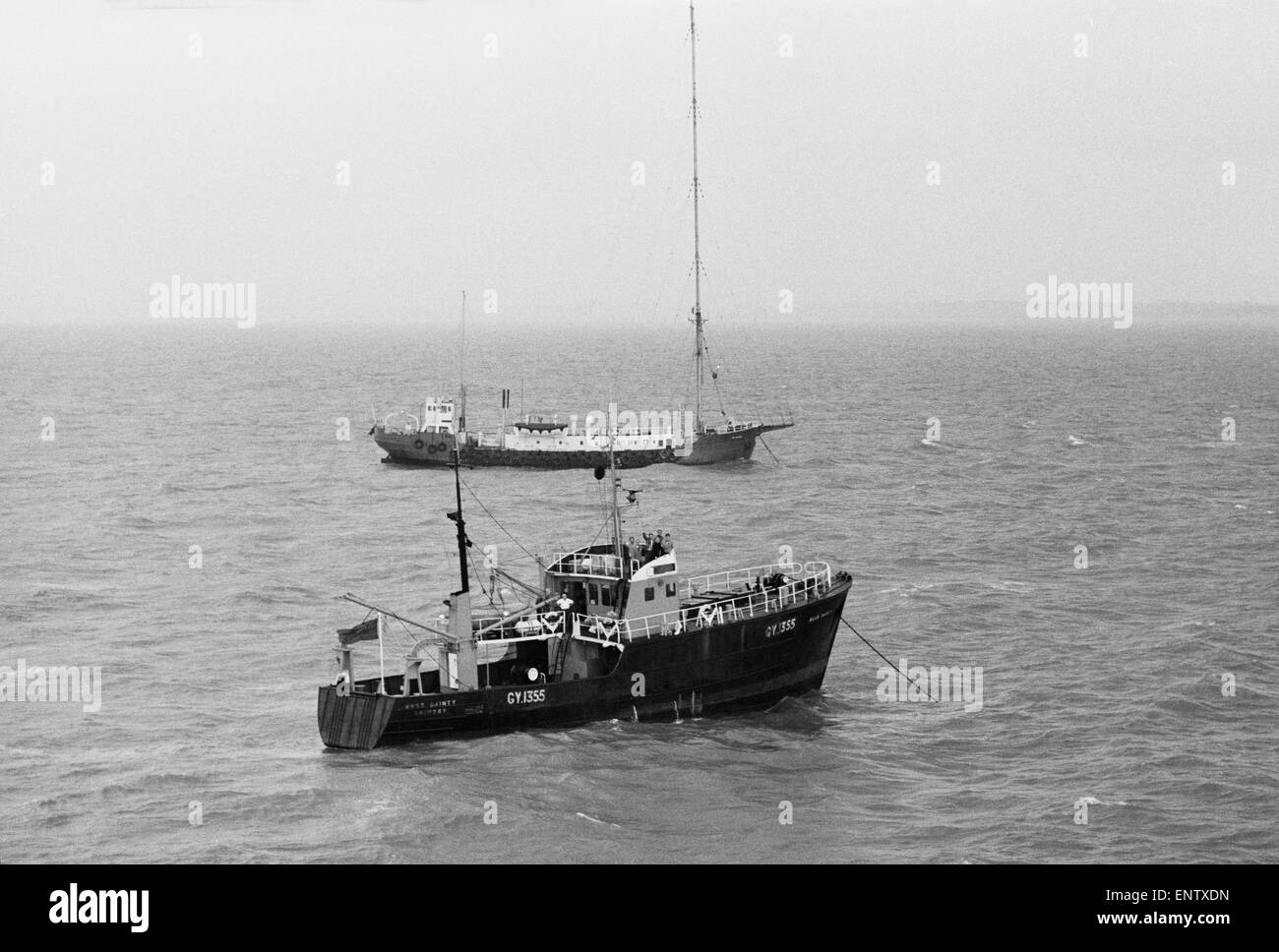 The trawler Ross Dainty, with a Granada television crew on board, is tossed by the swell as she lies at anchor in front of the pop pirate ship Radio Caroline. 13th September 1967. Stock Photo