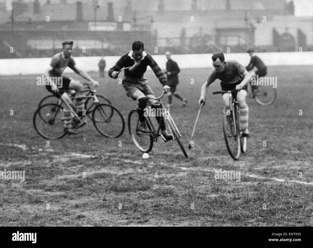 Three fellows playing Cycle polo which was invented in County Wicklow, Ireland, in 1891 by retired cyclist, Richard J. Mecredy. The sport is similar to traditional polo, except that bicycles are used instead of horses. 19th September 1937 Stock Photo