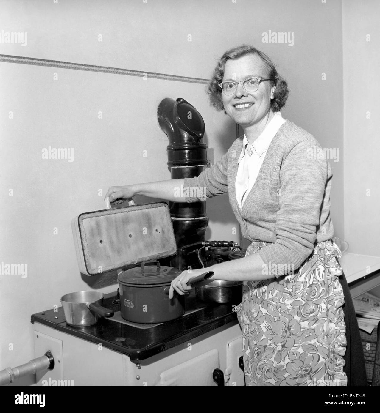 Domestic scenes: A woman cooking in her kitchen at home, 1954. Stock Photo