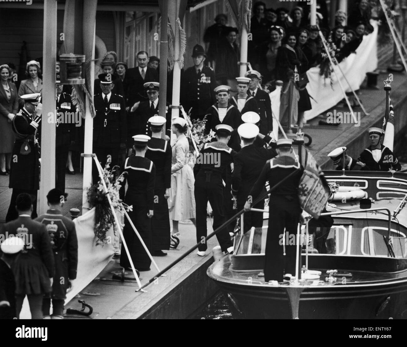 The Queen steps ashore from the Royal Barge at Wesminster Pier met by her family and Admirals of the fleet. 15th May 1954. Stock Photo