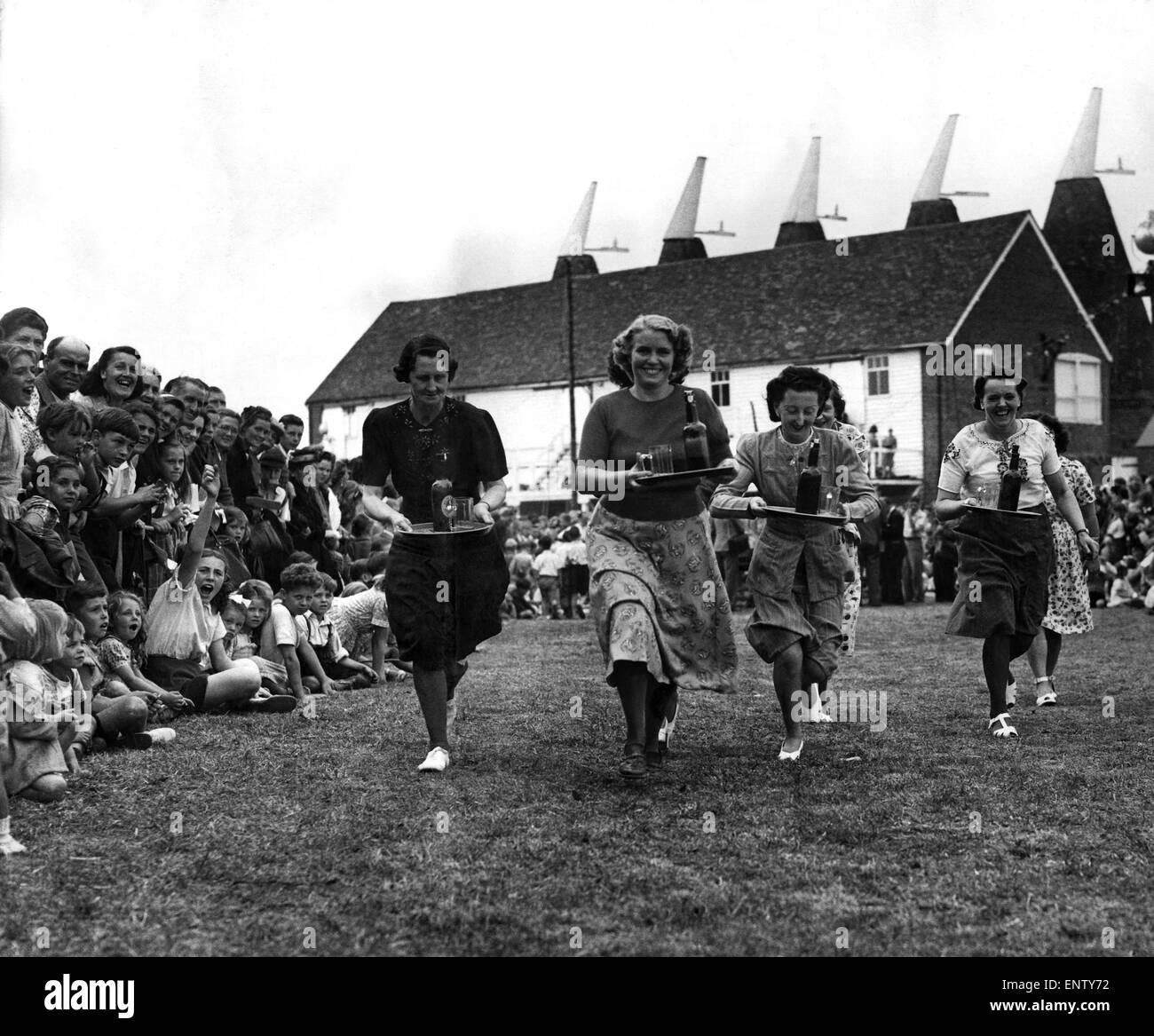 The annual festival at Paddock Wood, Kent of the Hop Season started. The Bardmaids race where they have to spring 100 yards, pour out a glass of beer, drink it and run back with the tray and bottle half full. 8th September 1949 Stock Photo