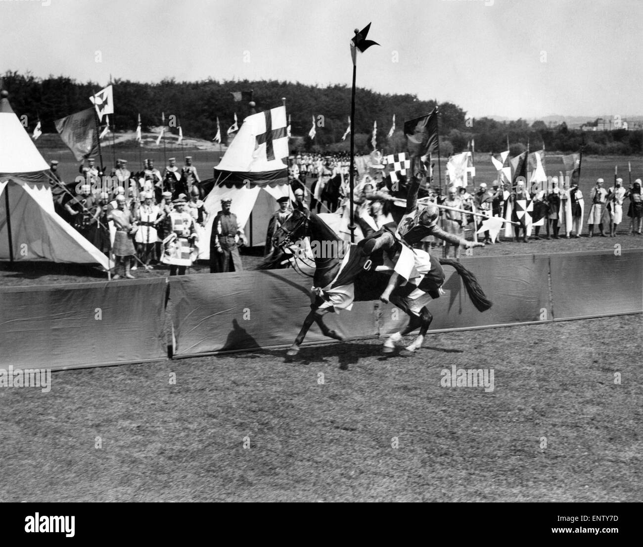 King Richard I and his attendants see an unknown knight unhorse his opponent in the jousting at a rehearsal of the remarkable Aldershot Searchlight Tattoo which opens on June 18th. P003614 Stock Photo