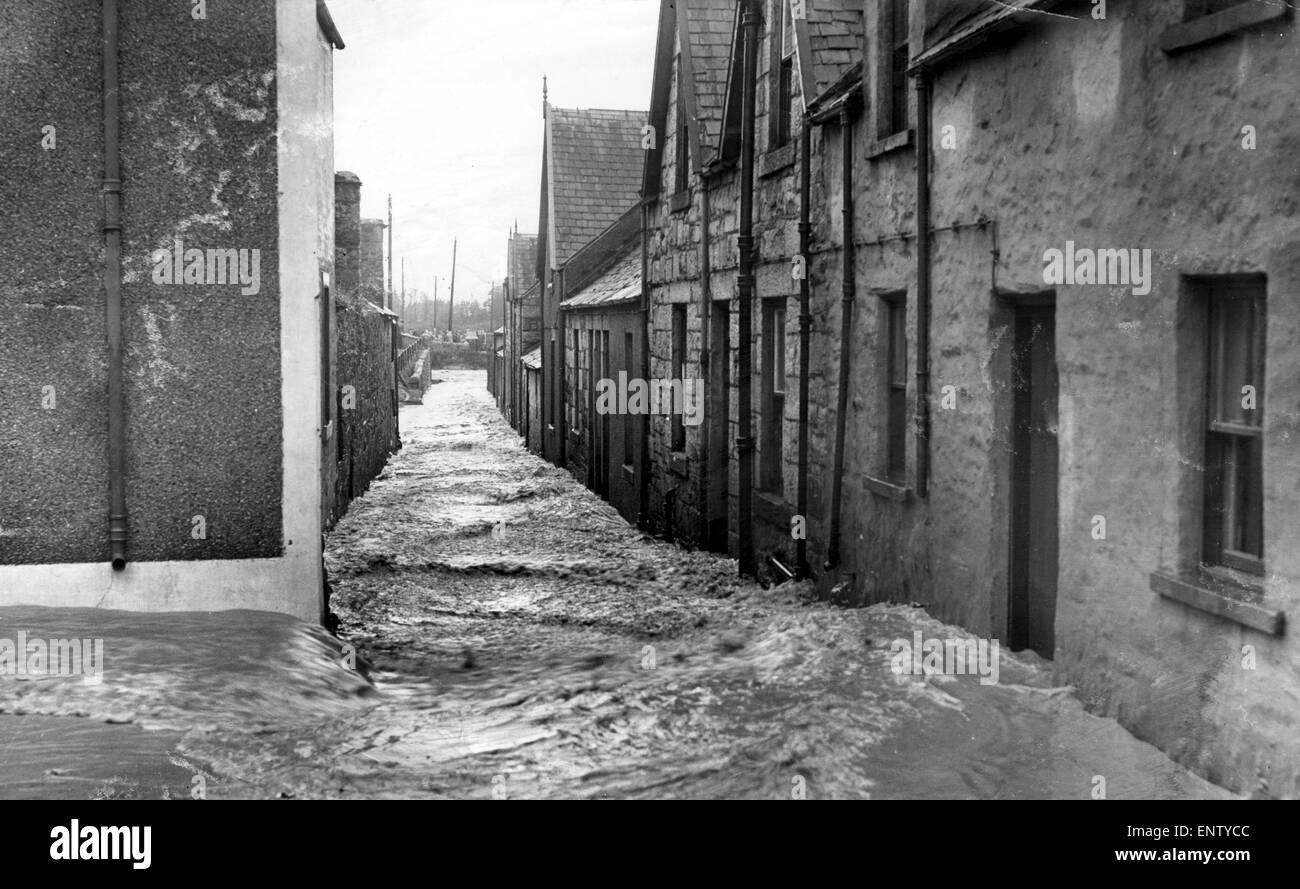 The only sound is the raw and swish of the water, in one of the deserted streets of Creetown, in Dumfries and Galloway (South West Scotland), on the north side of the Solway Firth, 10th November 1954. Stock Photo