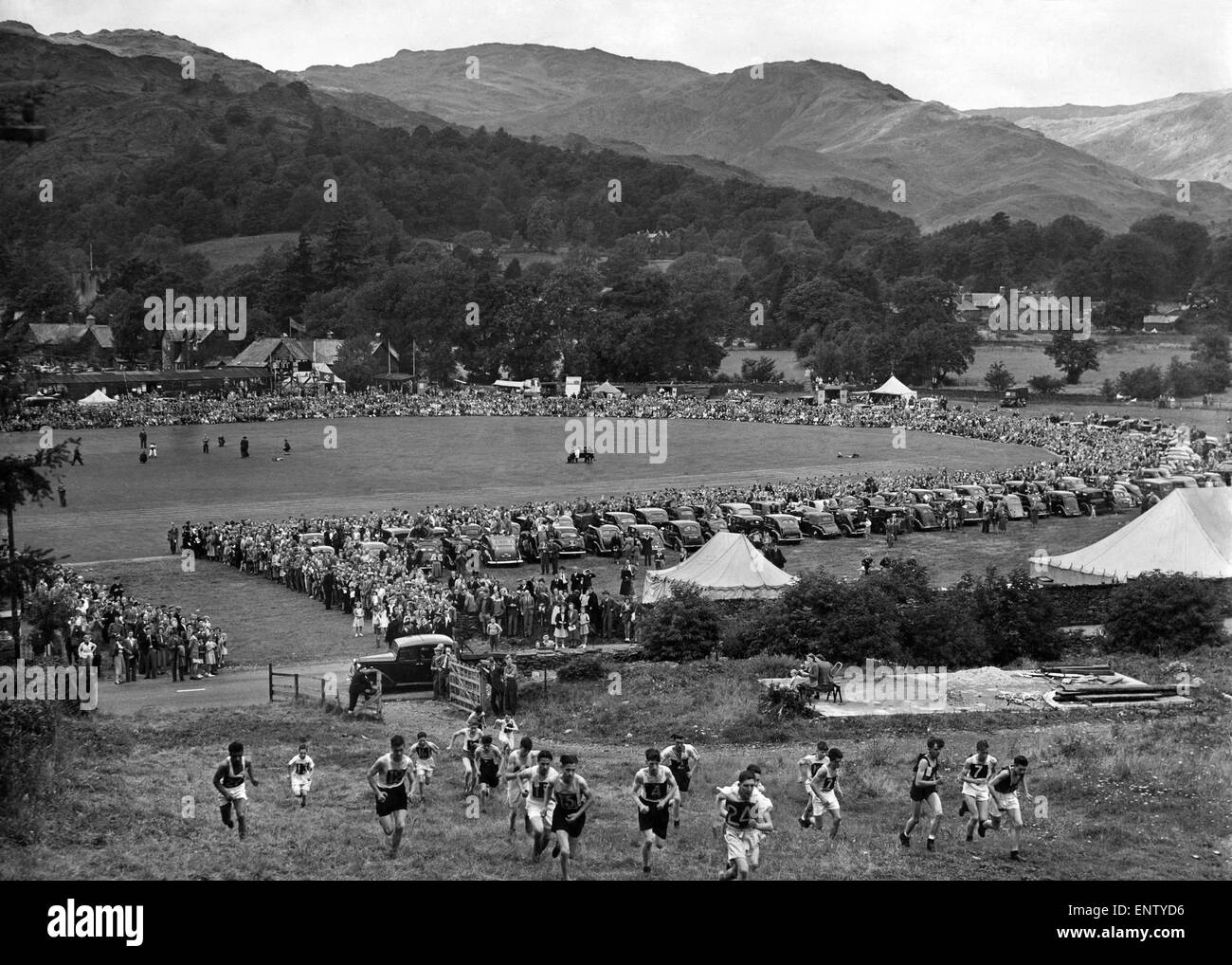 Grasmere Sportsand Show 1951. The Juvenile Guides race, the runners have just left the arena in the background and are making the ascent, to the top of the mountain turn around a flag and decend, at a fast running speed. August 1951 P002552 Stock Photo