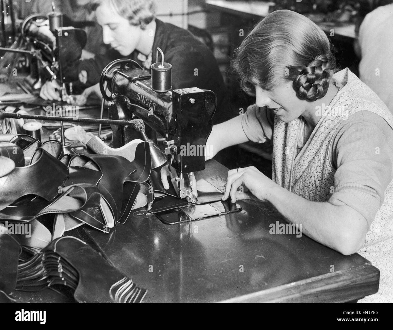 A woman machinist seen here of the factory floor of J Searsy of Northampton sewing uppers . 6th April 1930 Stock Photo