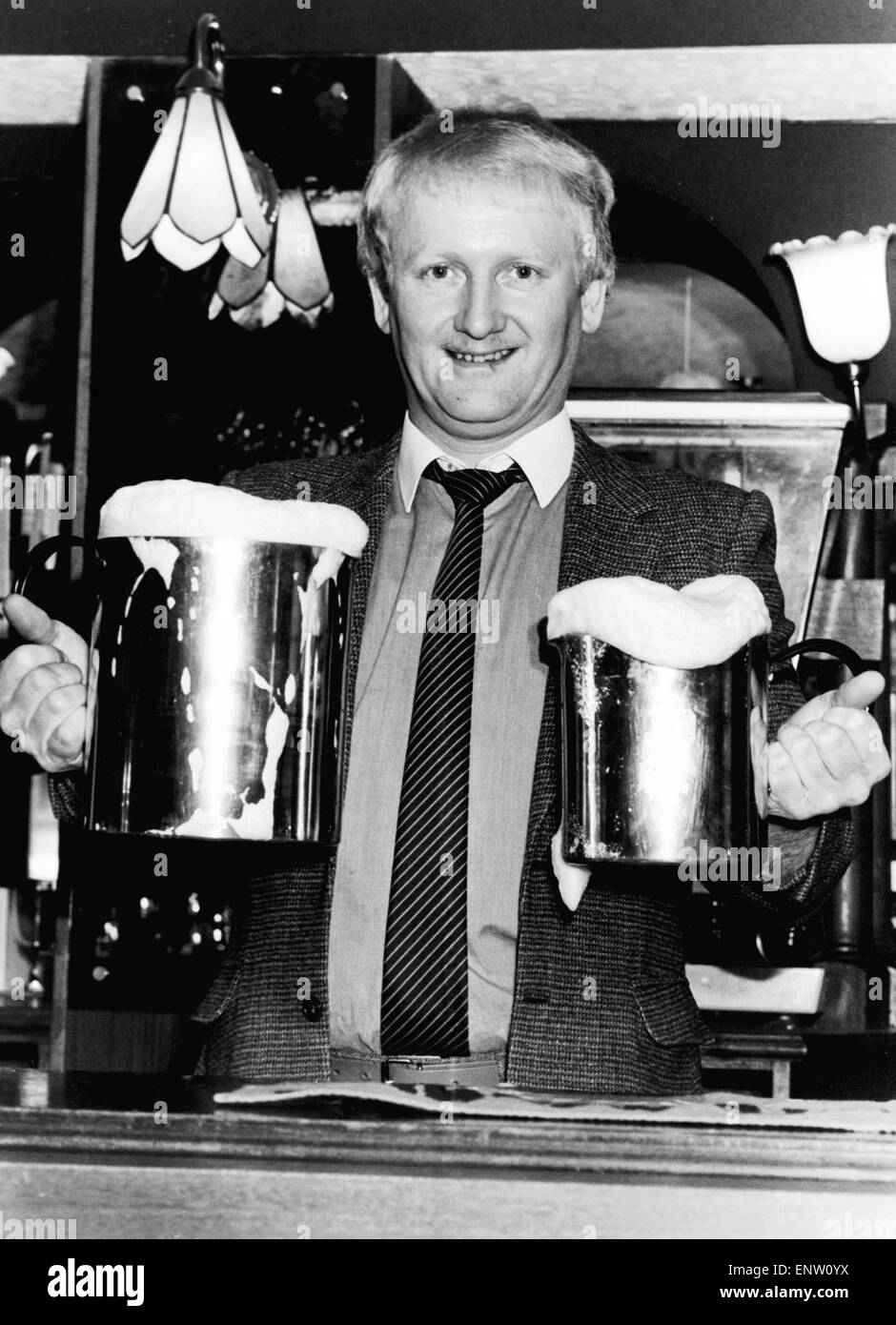 Calling all big drinkers! Landlord Ron Lambton serves his beer in quarts to one gallon pots. He hit on the idea to cut queueing at the bar and reduce the washing up. Bulk buying gives his customers a cheaper night too - 'I hardly sell pints at all now,' he said. 26th February 1985 Stock Photo