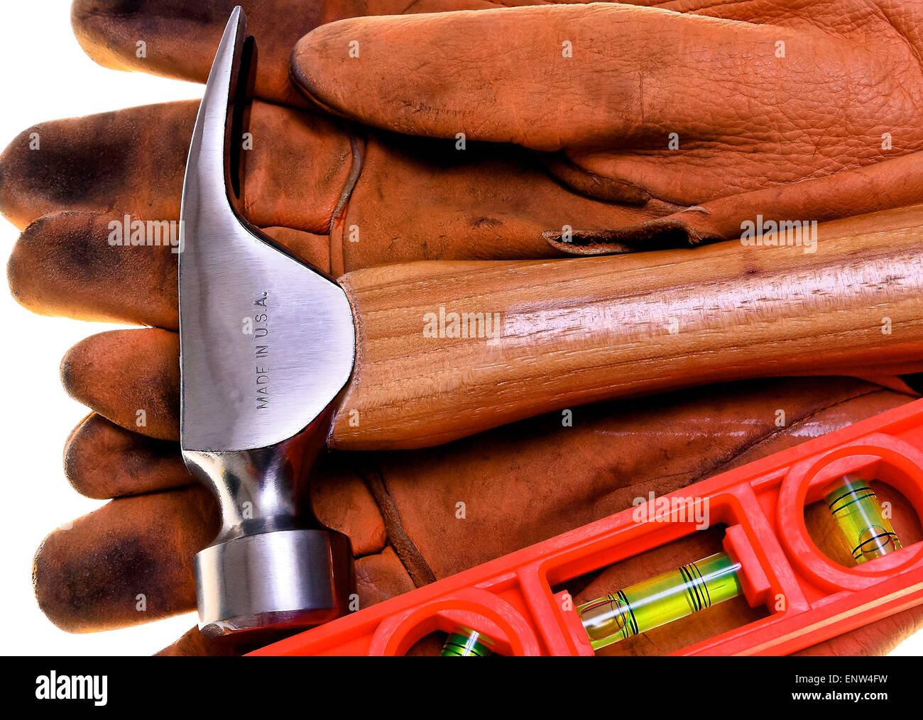 Closeup of new construction framing hammer and bubble level on heavy leather work gloves Made In America Stock Photo