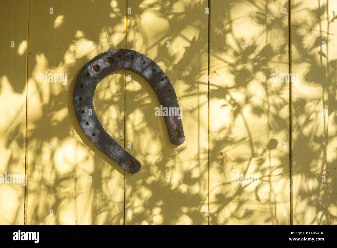 old horseshoe hanging on the wooden wall of a house Stock Photo