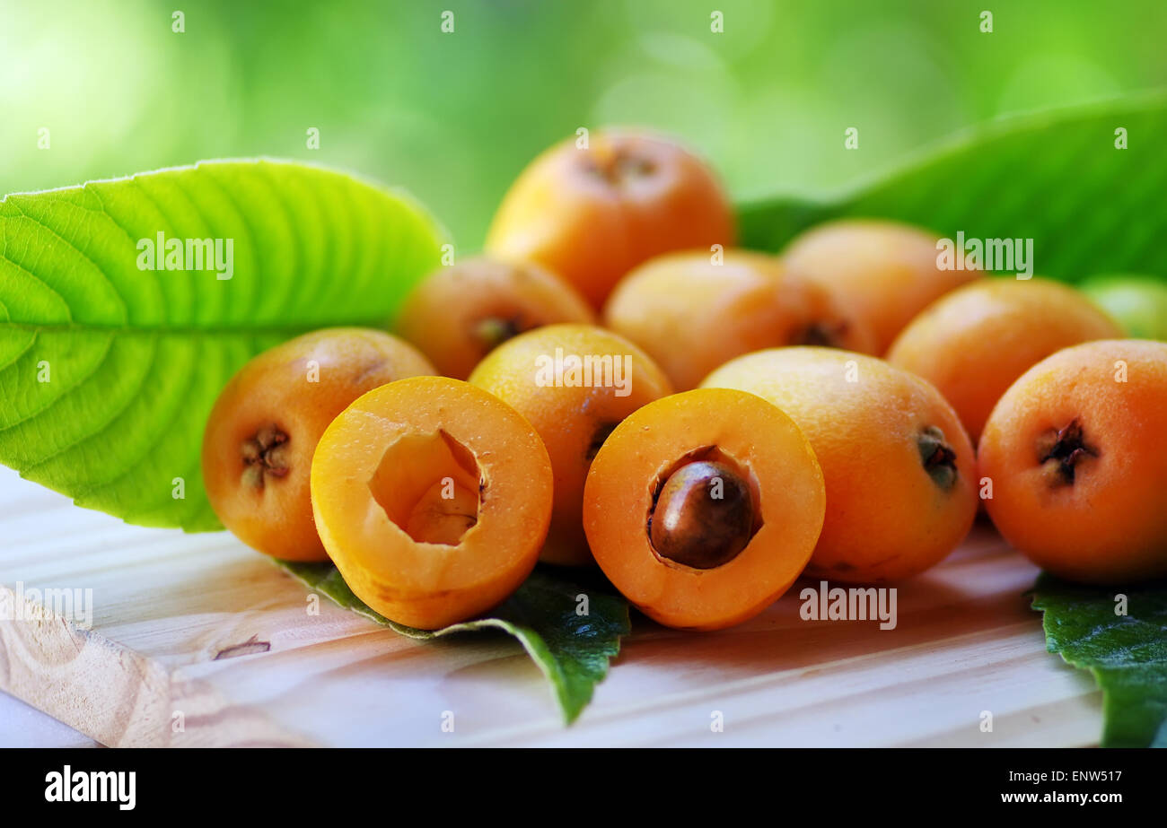 Loquat Medlar fruit isolated on a green background Stock Photo
