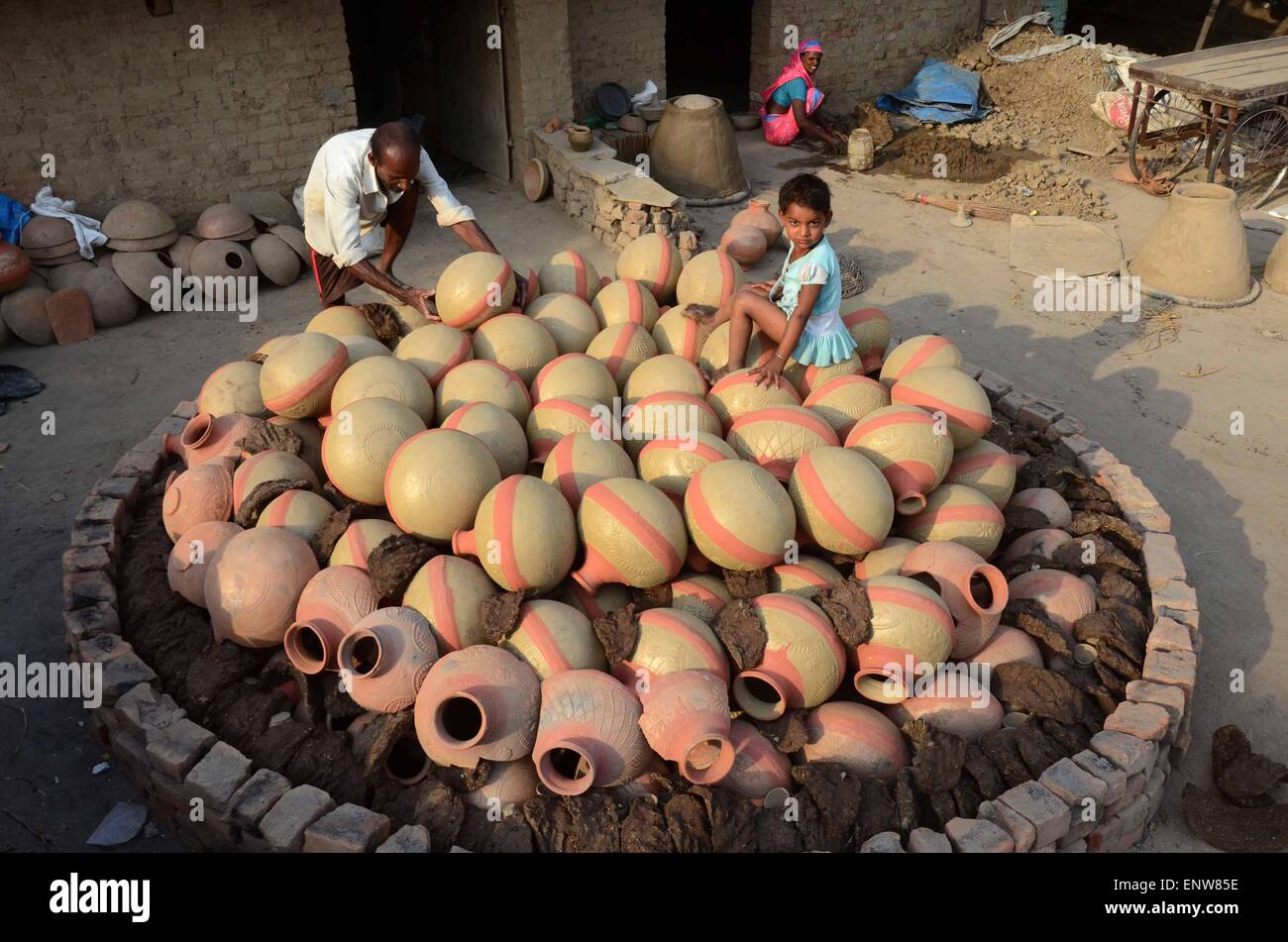 Allahabad, India. 11th May, 2015. A potter puts the earthen pitcher on