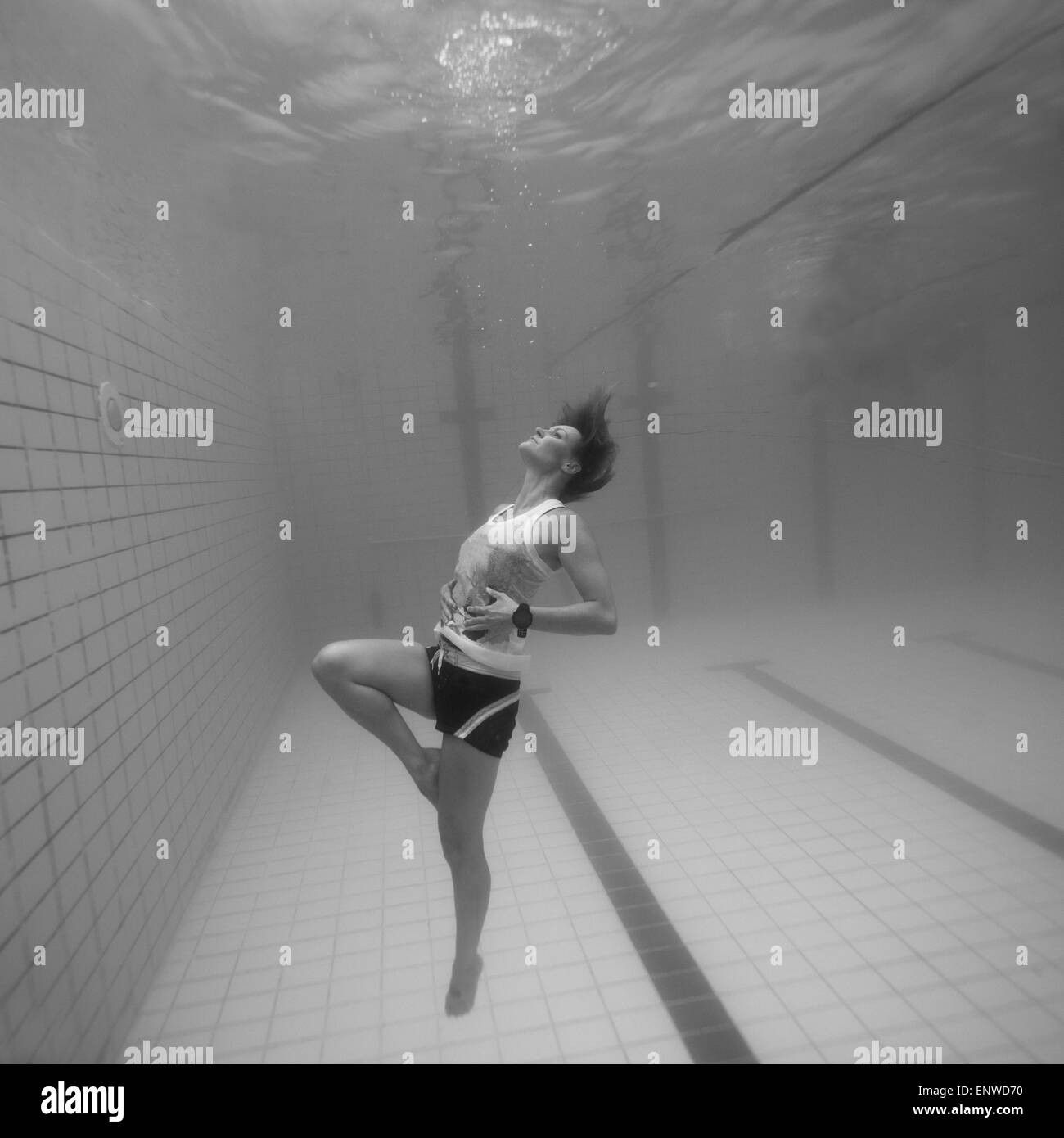 Woman freediving underwater in a pool Stock Photo