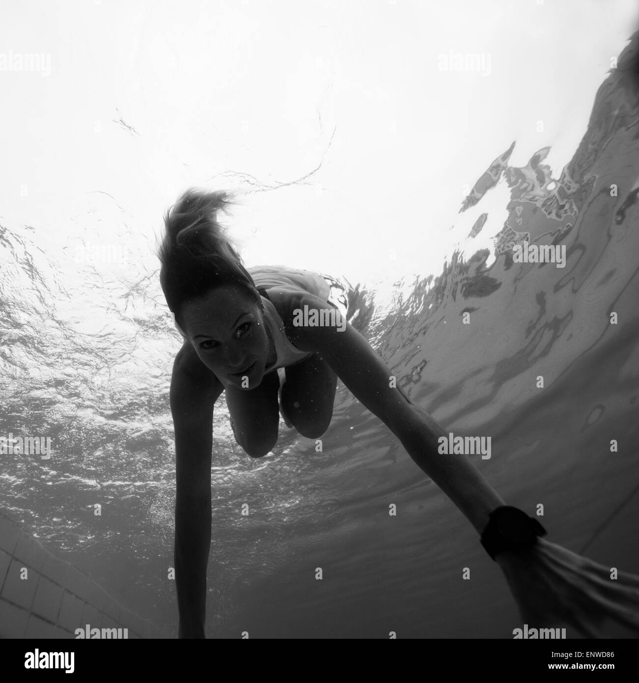 Woman freediving underwater in a pool Stock Photo