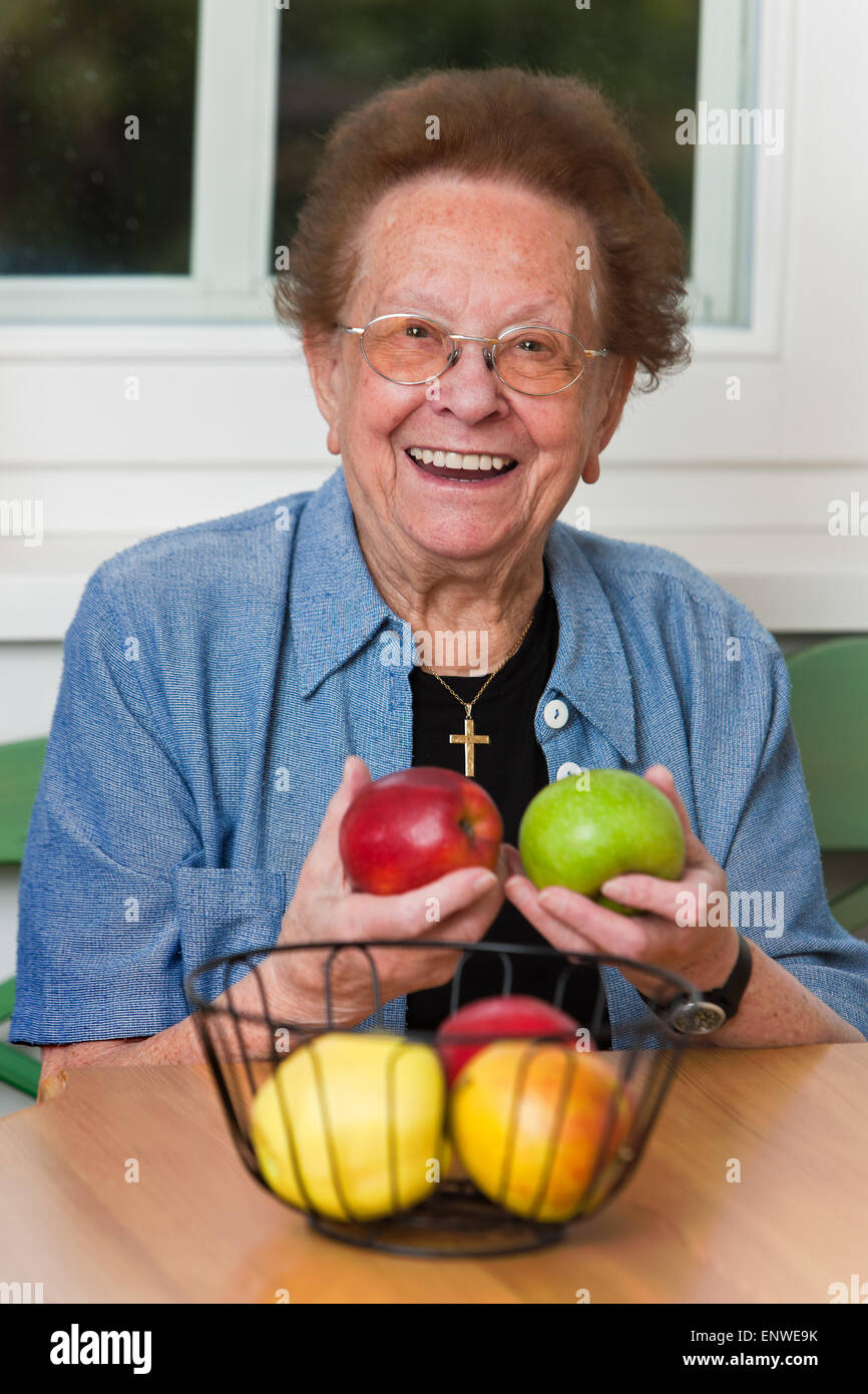 Senior woman showing apples Stock Photo