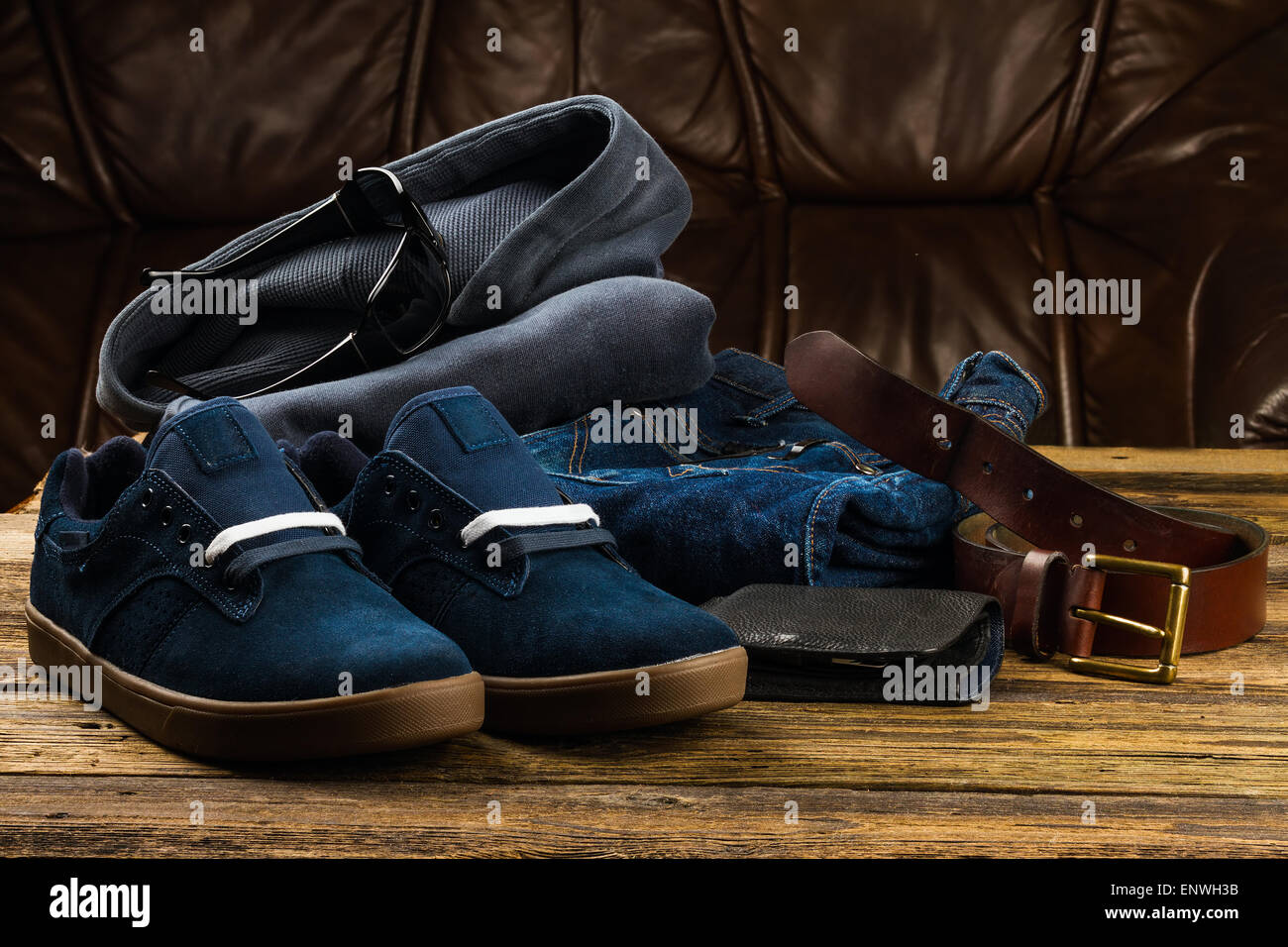 dark blue men's shoes, jeans,  pullover hoodie sweatshirt and accessories  on wooden background Stock Photo