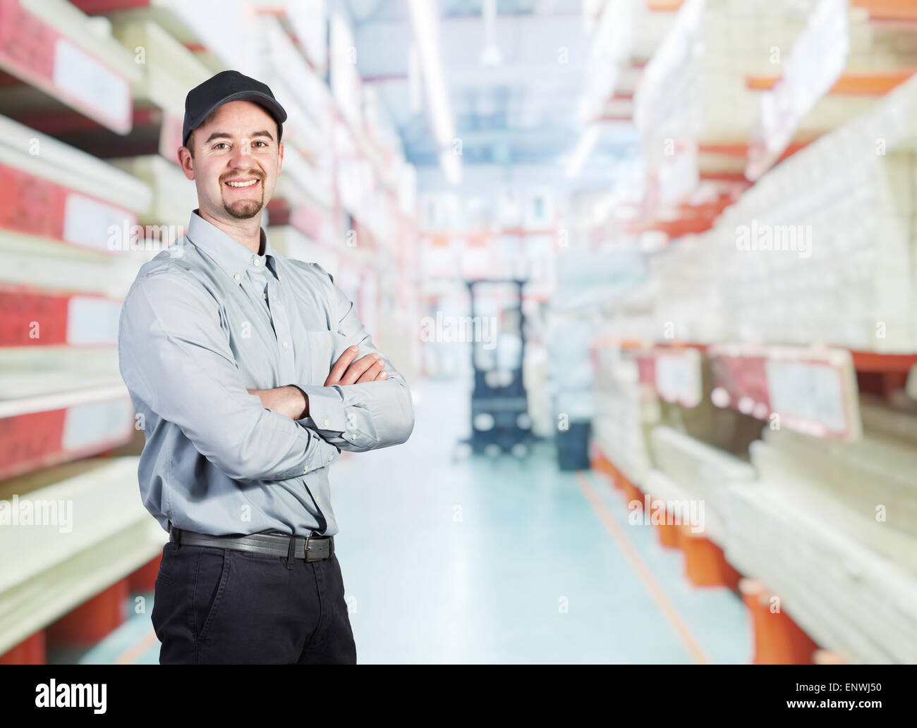 smiling worker crossed arms in warehouse Stock Photo - Alamy