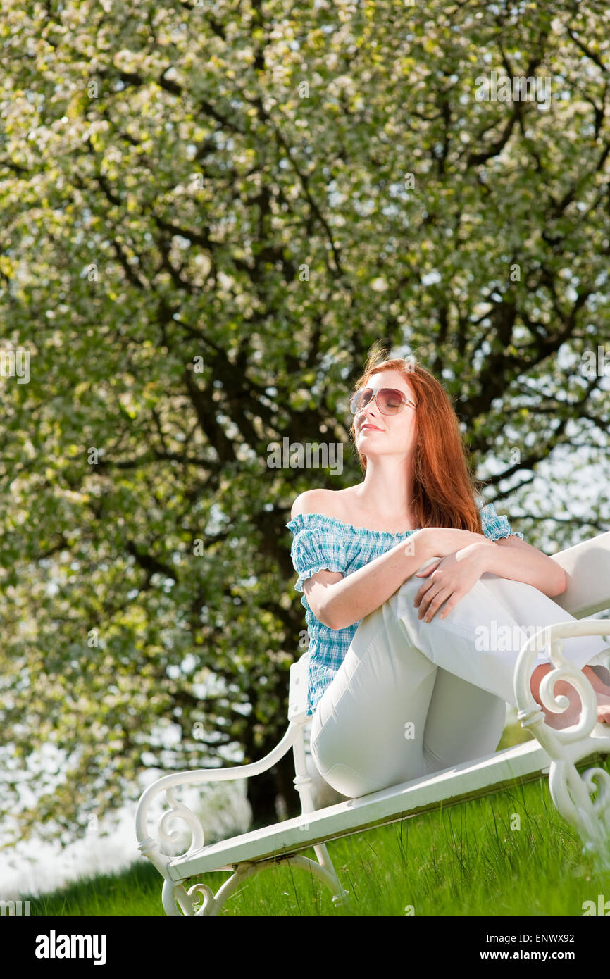 Young woman relaxing under blossom tree in spring Stock Photo - Alamy