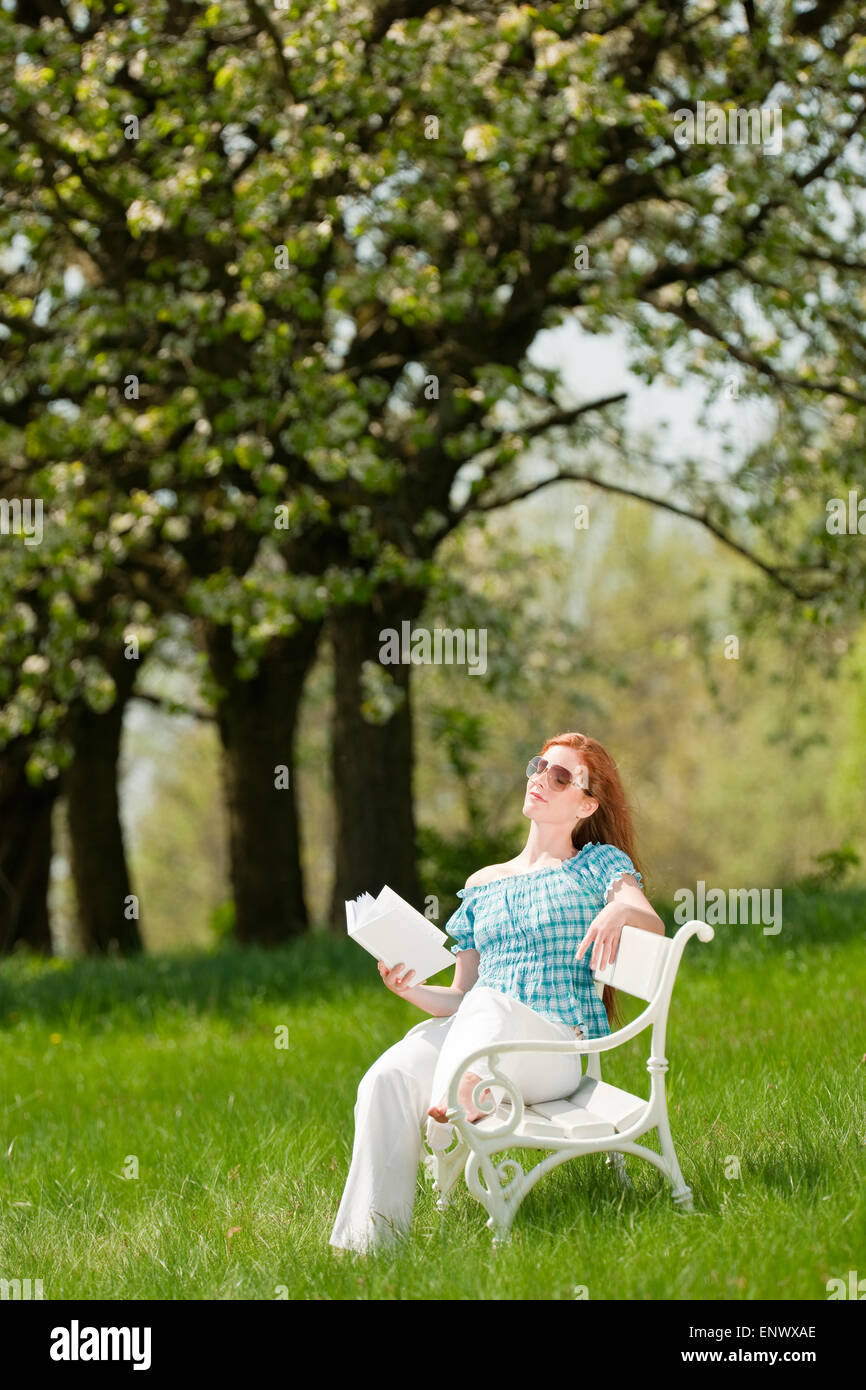 Young woman relaxing under blossom tree in spring Stock Photo - Alamy