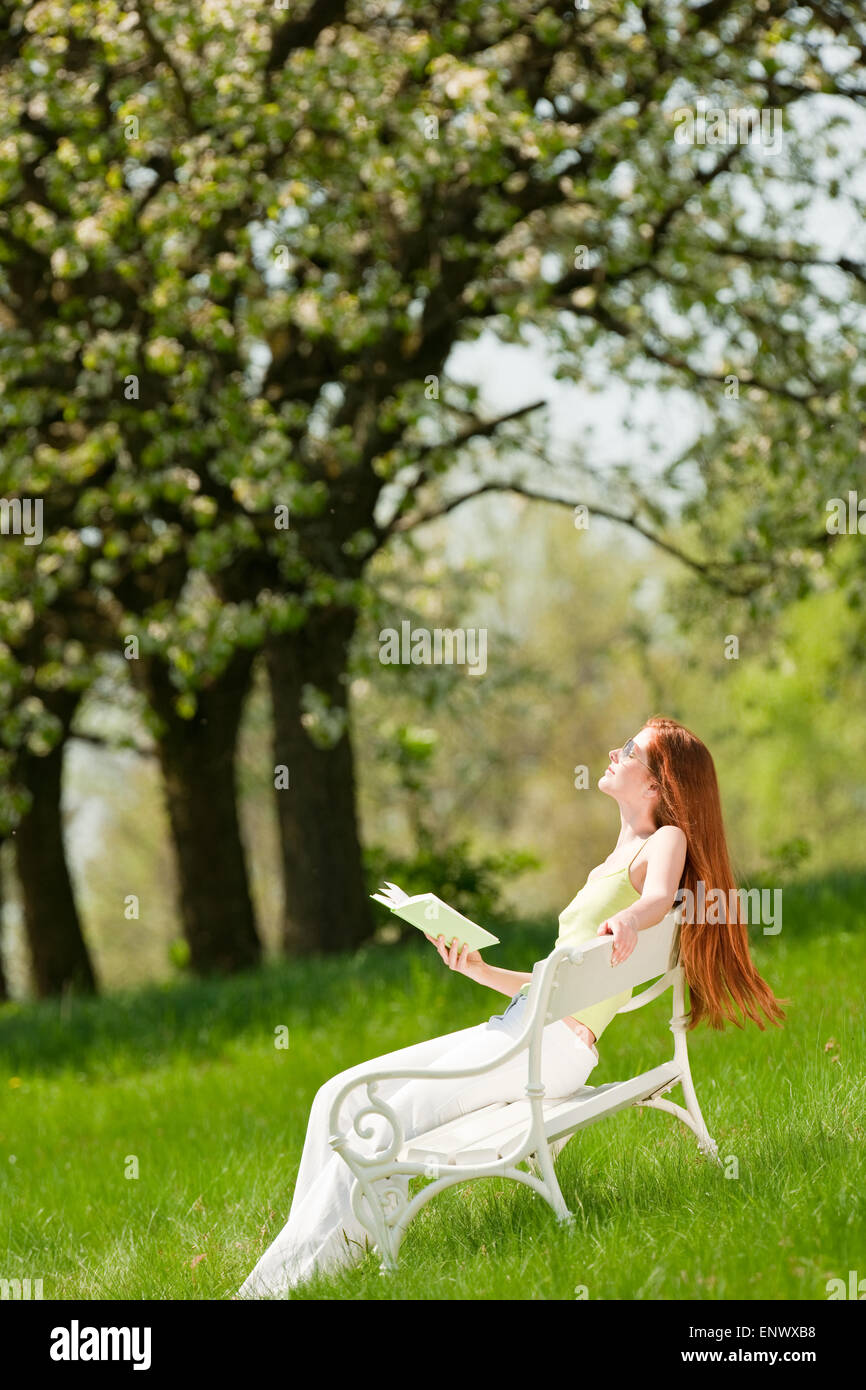 Young woman relaxing under blossom tree in spring Stock Photo - Alamy