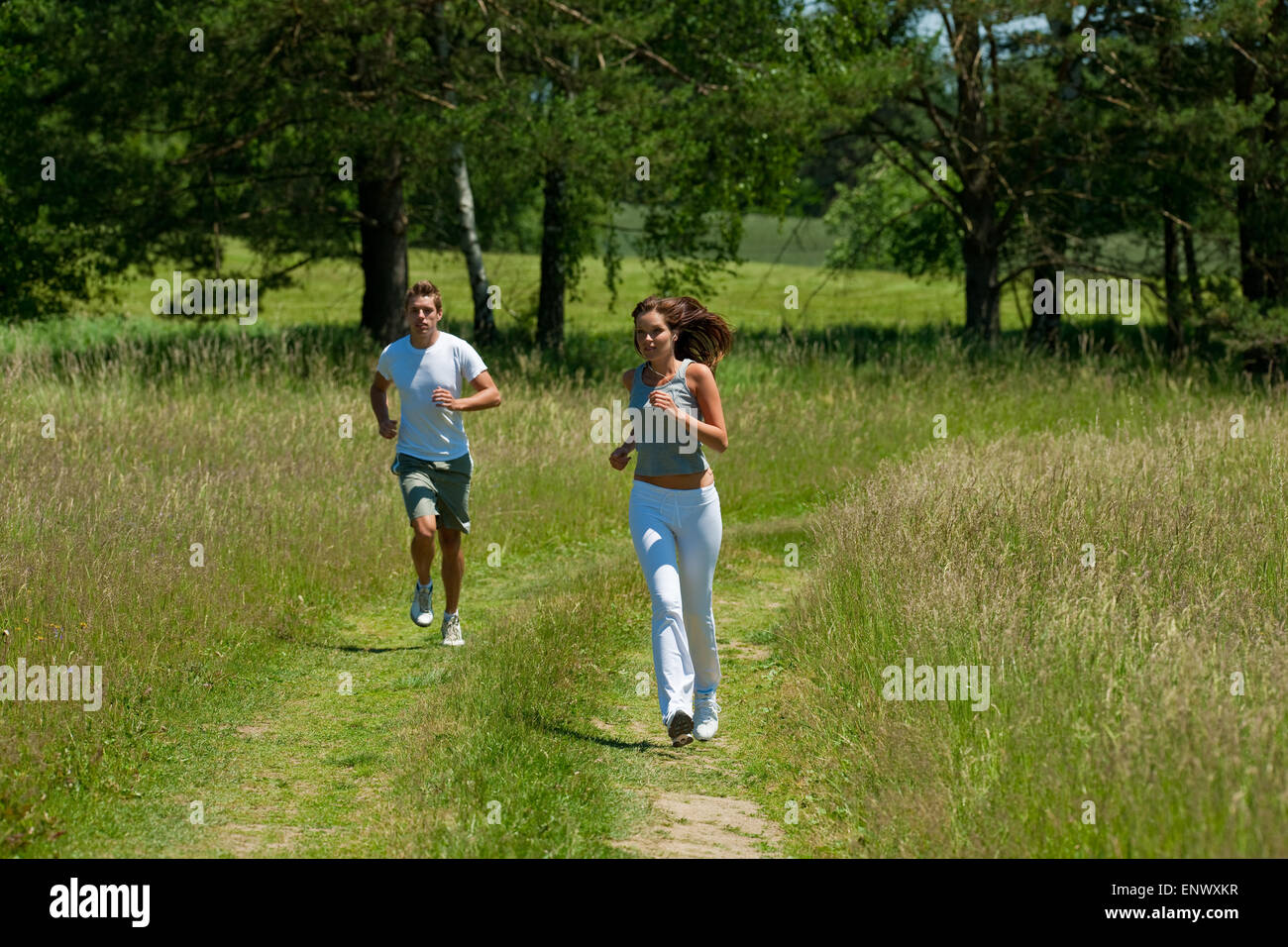 Young couple jogging outdoors in spring nature Stock Photo - Alamy
