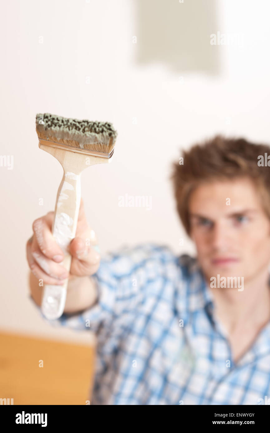 Home improvement Young man holding paint brush Stock Photo Alamy