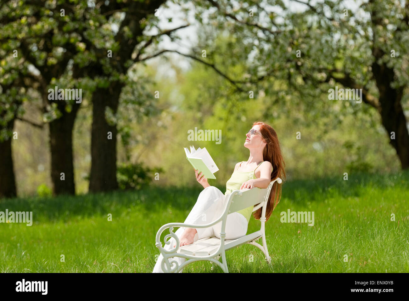 Young woman relaxing under blossom tree in spring Stock Photo - Alamy