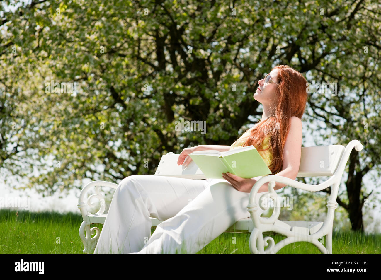 Young woman relaxing under blossom tree in spring Stock Photo - Alamy