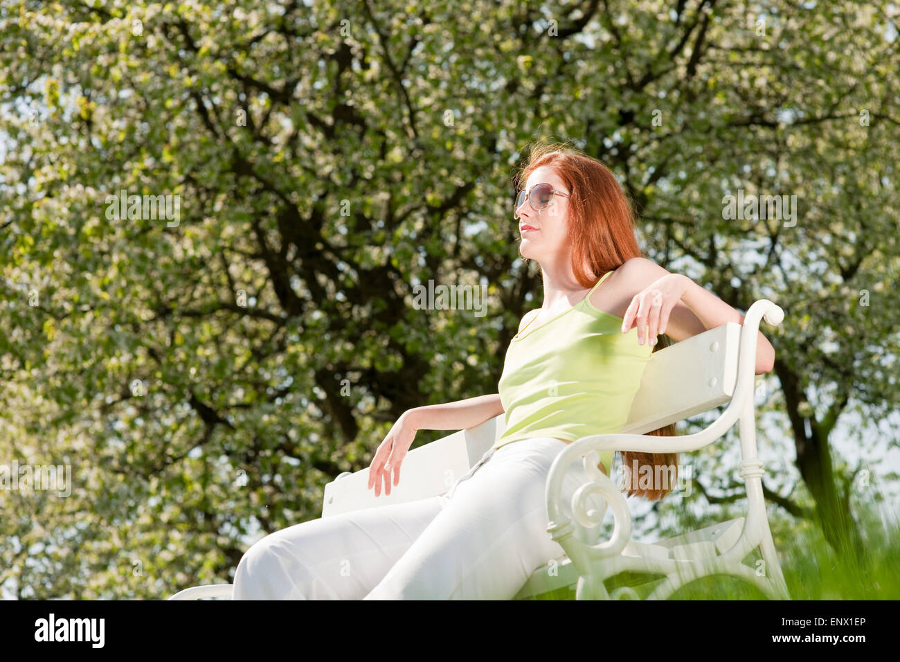 Young woman relaxing under blossom tree in spring Stock Photo - Alamy