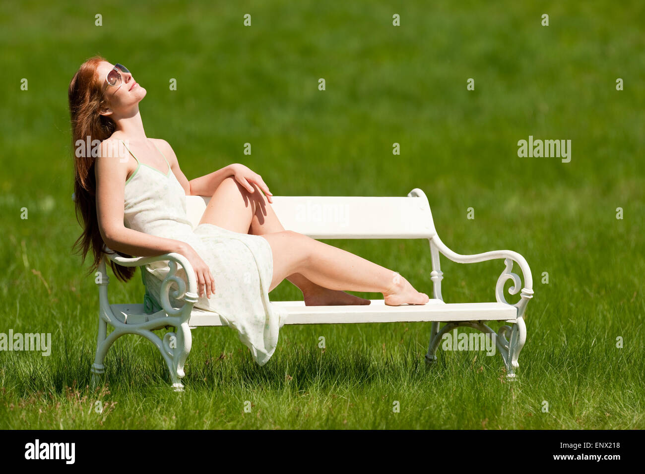Red hair woman sitting on white bench in spring Stock Photo - Alamy