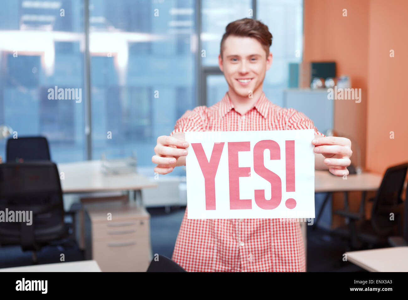 Office worker holding poster with yes slogan Stock Photo Alamy