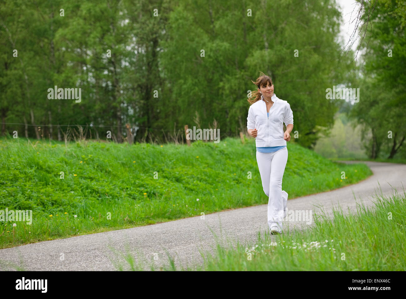 Jogging - sportive woman running on road in nature Stock Photo