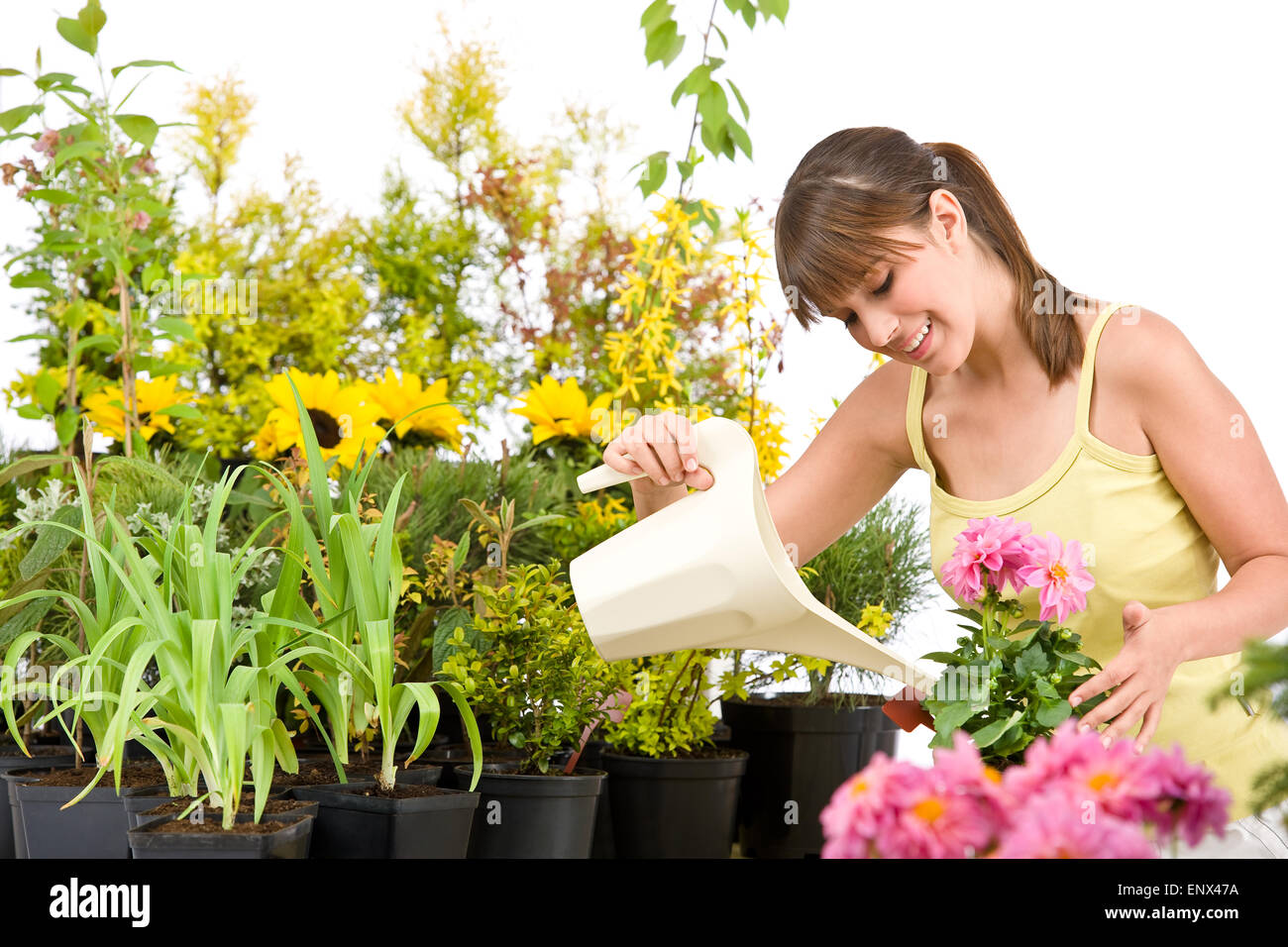 Gardening - woman with watering can and flowers pouring water Stock Photo