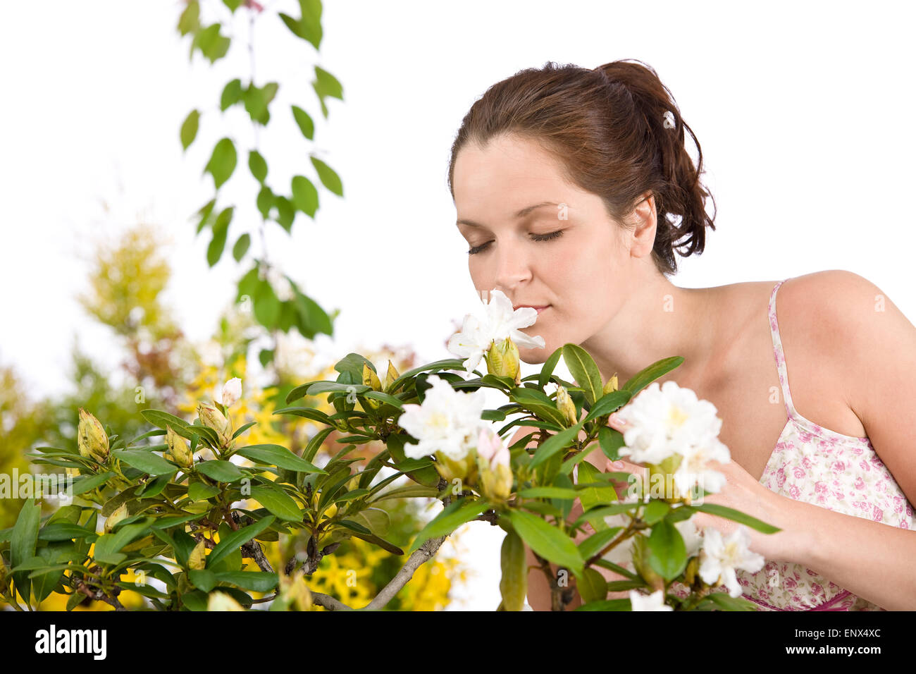 Portrait of woman smelling blossom of Rhododendron flower Stock Photo
