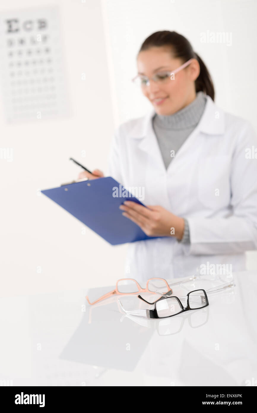 Optician doctor woman with glasses and eye chart Stock Photo