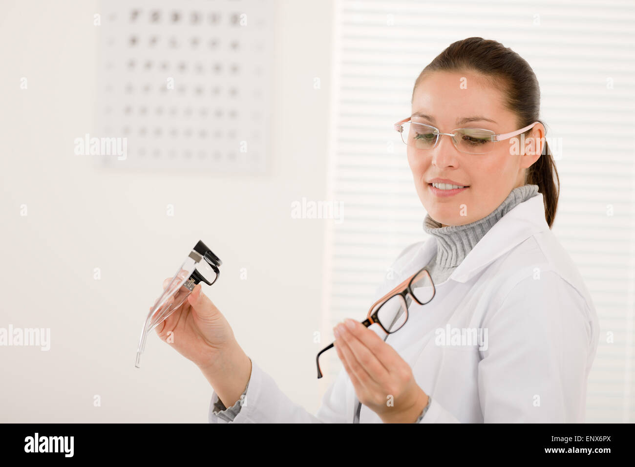Optician doctor woman with glasses and eye chart Stock Photo