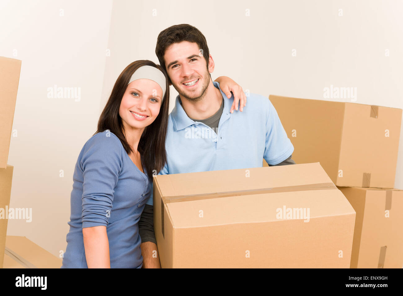 Moving home young couple carrying cardboard boxes Stock Photo - Alamy